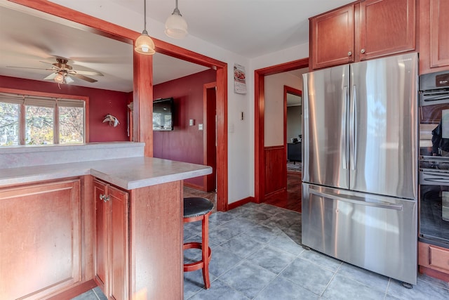 kitchen with light countertops, freestanding refrigerator, oven, and ceiling fan