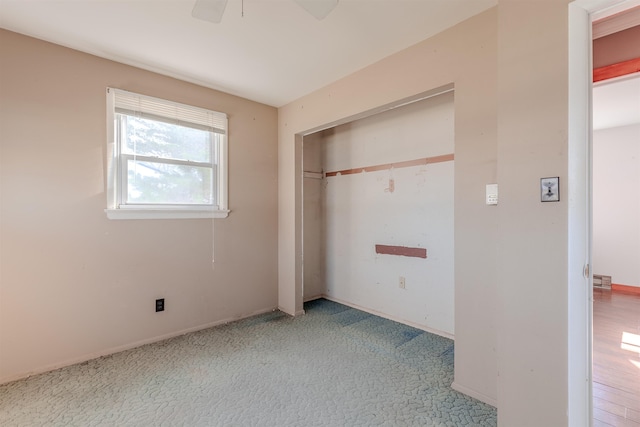 unfurnished bedroom with carpet flooring, a closet, baseboards, and ceiling fan