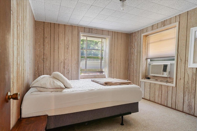 carpeted bedroom featuring cooling unit and wooden walls