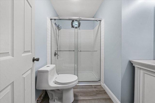 bathroom featuring walk in shower, hardwood / wood-style floors, and toilet