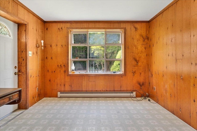 interior space featuring wood walls, crown molding, and a baseboard heating unit