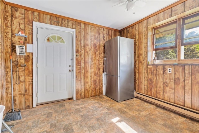 entryway with ceiling fan, wood walls, crown molding, and a baseboard radiator