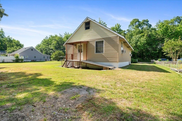 rear view of property featuring a lawn