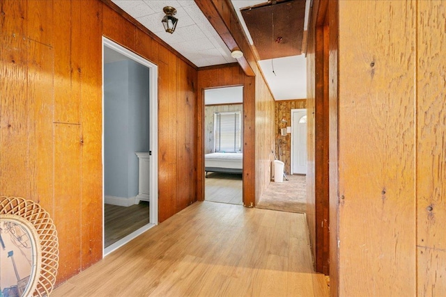 hall featuring wood walls and light wood-type flooring