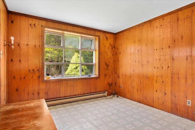 unfurnished room featuring wooden walls, a wealth of natural light, and a baseboard radiator