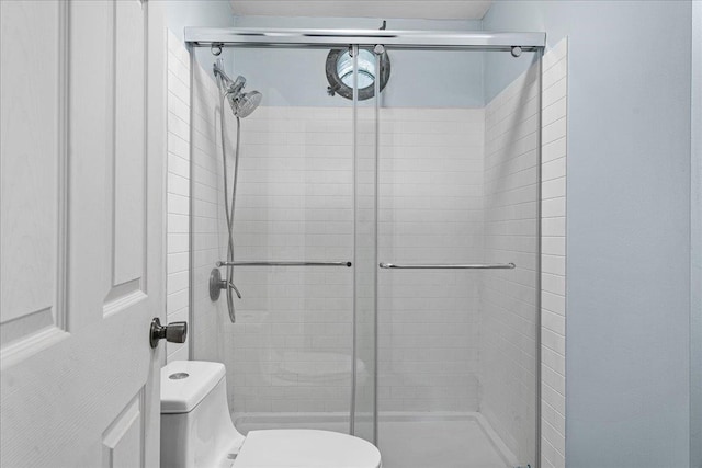 bathroom with an enclosed shower and toilet