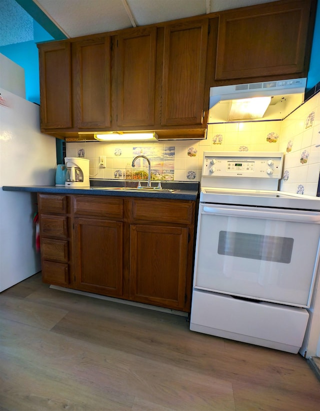 kitchen with ventilation hood, white electric stove, tasteful backsplash, and light hardwood / wood-style flooring