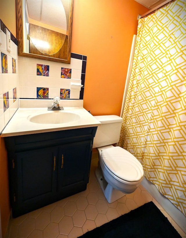 bathroom featuring tasteful backsplash, tile patterned flooring, vanity, and toilet