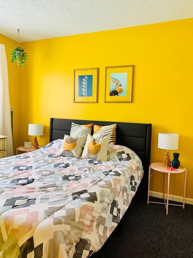 bedroom with carpet floors and a textured ceiling