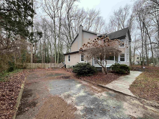 48 Secluded Ln, Rio Grande, NJ 08242 - view of side of home with a porch, a chimney, and fence