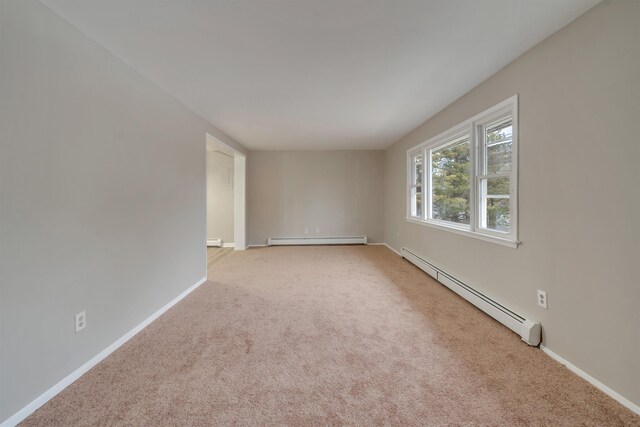 carpeted spare room featuring baseboard heating