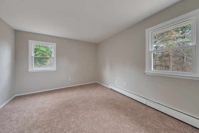 carpeted spare room with a baseboard heating unit