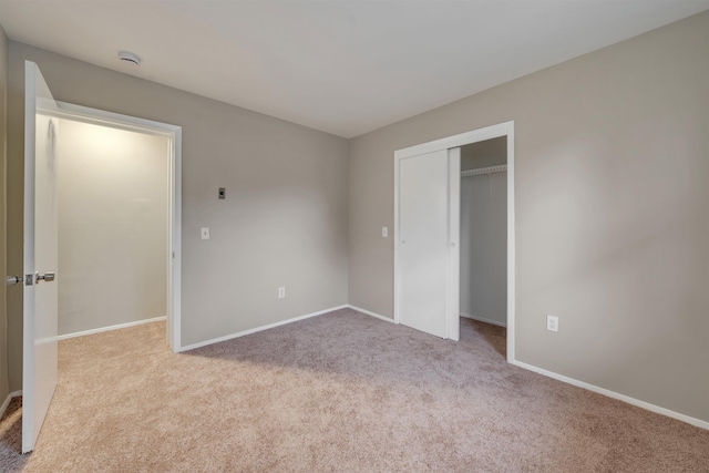 unfurnished bedroom with light carpet and a closet