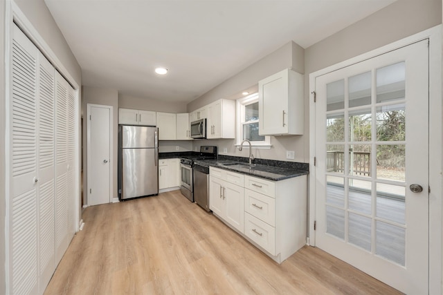 kitchen with stainless steel appliances, sink, and white cabinets