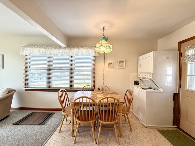 carpeted dining space featuring stacked washer and dryer