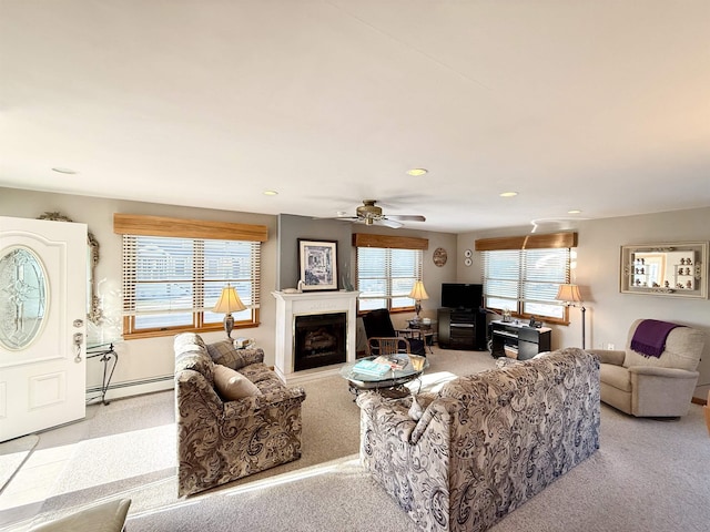 living room featuring ceiling fan, light colored carpet, and baseboard heating