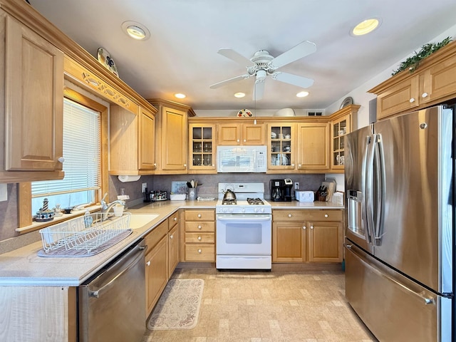 kitchen featuring ceiling fan, sink, stainless steel appliances, and tasteful backsplash