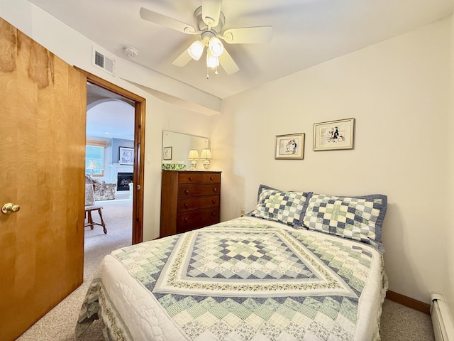 bedroom with ceiling fan, a baseboard radiator, and carpet floors