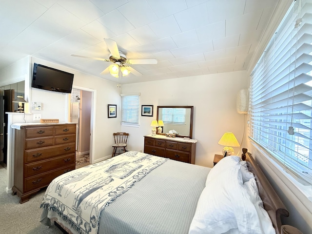 carpeted bedroom featuring ceiling fan and multiple windows