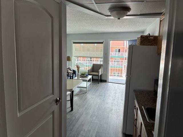 9101 Atlantic Ave Unit 303, Wildwood Crest, NJ 08260 - kitchen featuring wood finished floors, freestanding refrigerator, and a textured ceiling
