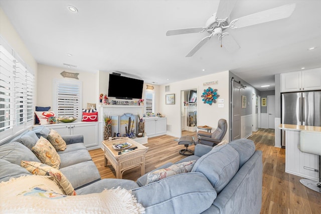 living room featuring light hardwood / wood-style floors and ceiling fan