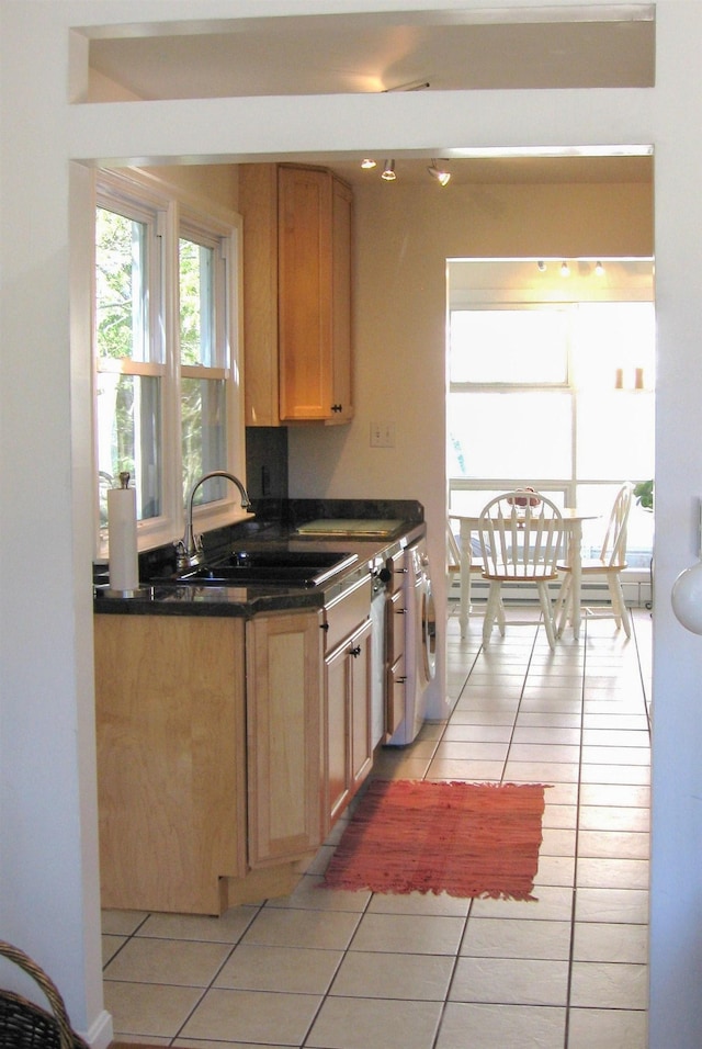 kitchen featuring sink, light tile patterned floors, and washer / dryer