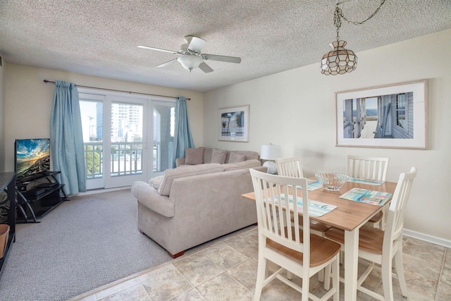 carpeted dining area featuring ceiling fan and a textured ceiling