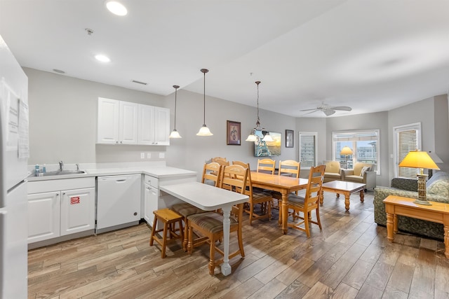 kitchen featuring white cabinetry, sink, light hardwood / wood-style flooring, and dishwasher