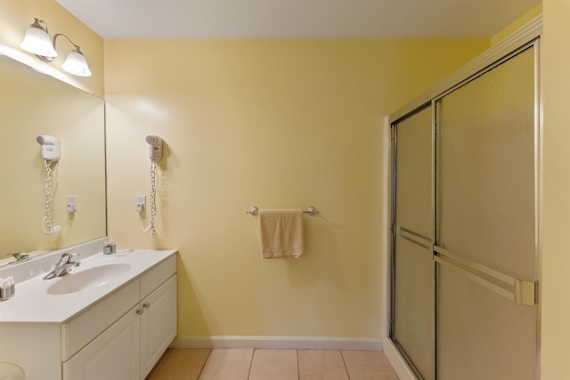 bathroom featuring tile patterned flooring, vanity, and walk in shower