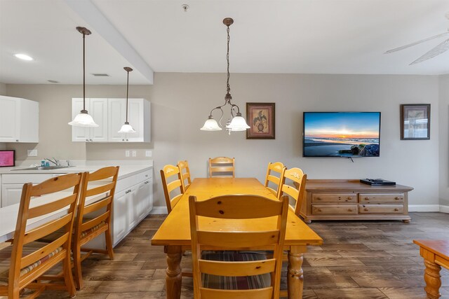 dining room featuring an inviting chandelier, sink, and dark wood-type flooring