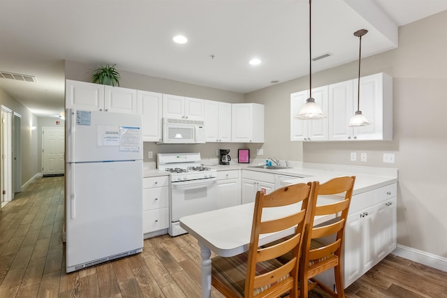 kitchen featuring white appliances, decorative light fixtures, dark hardwood / wood-style floors, and white cabinets