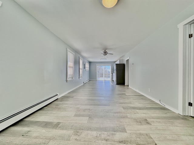 unfurnished room featuring light hardwood / wood-style floors, a baseboard heating unit, and ceiling fan