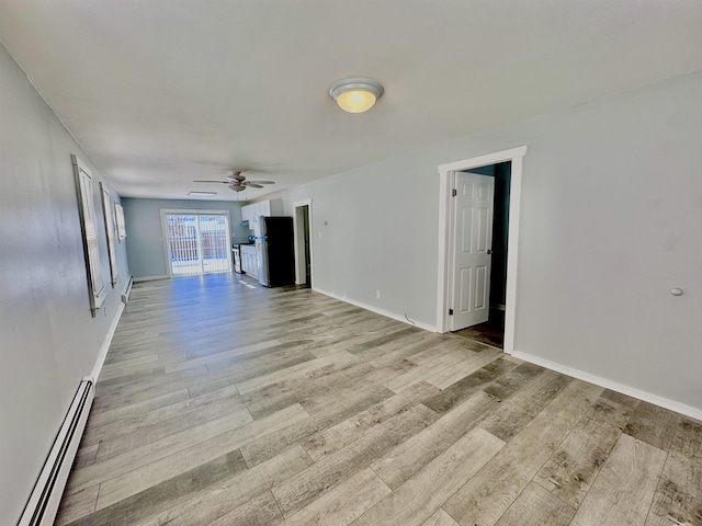 empty room with ceiling fan, light hardwood / wood-style flooring, and a baseboard radiator