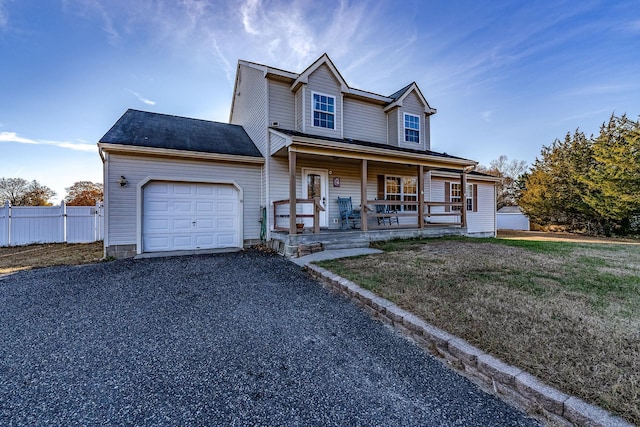 view of front of house with a front yard, a porch, and a garage