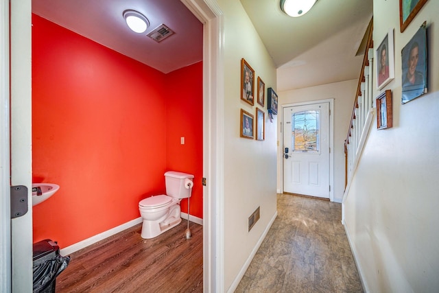 bathroom with wood-type flooring, lofted ceiling, and toilet