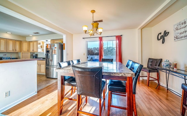 dining space with a chandelier and light wood-type flooring