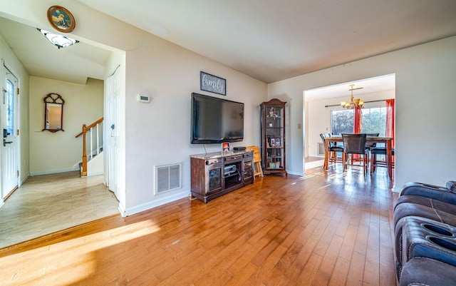 living room with an inviting chandelier and hardwood / wood-style flooring