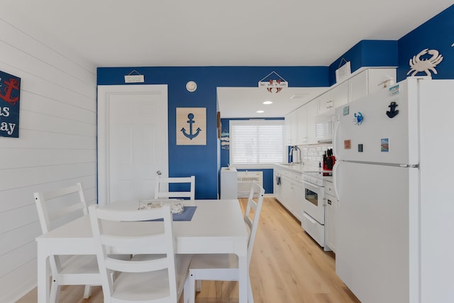 kitchen featuring white cabinets, light wood-type flooring, white appliances, and sink