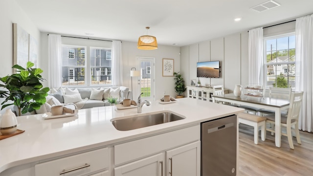 212 Bentz Ave, Villas, NJ 08251 - kitchen with stainless steel dishwasher, a sink, light wood-style floors, white cabinetry, and open floor plan