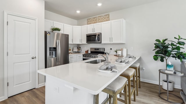 212 Bentz Ave, Villas, NJ 08251 - kitchen featuring appliances with stainless steel finishes, a breakfast bar, a peninsula, wood finished floors, and recessed lighting