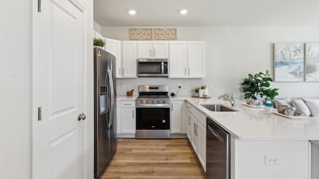 212 Bentz Ave, Villas, NJ 08251 - kitchen with stainless steel appliances, a sink, a peninsula, light countertops, and light wood finished floors