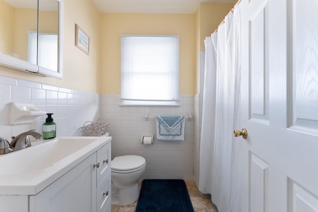 bathroom with tile patterned flooring, vanity, tile walls, and toilet