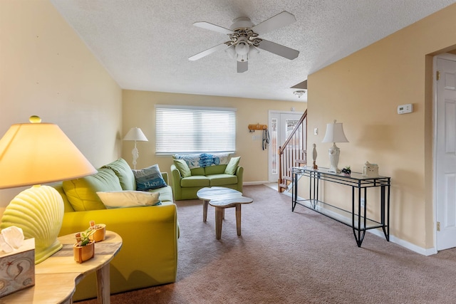 carpeted living room with a textured ceiling and ceiling fan