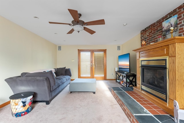 living room featuring ceiling fan, carpet flooring, and a tile fireplace