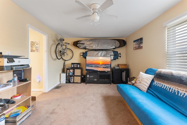 living area with light colored carpet and ceiling fan