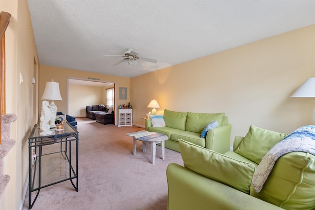 living room with light colored carpet, a textured ceiling, and ceiling fan