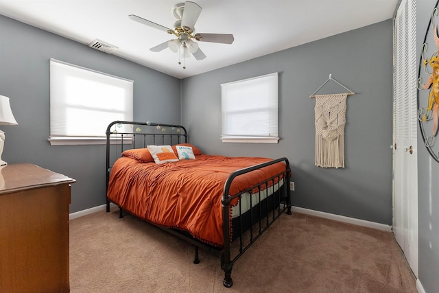 carpeted bedroom with multiple windows, ceiling fan, and a closet