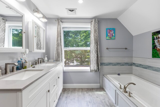 25 N 12th St, Del Haven, NJ 08251 - bathroom featuring double vanity, healthy amount of natural light, a garden tub, baseboards, and vaulted ceiling