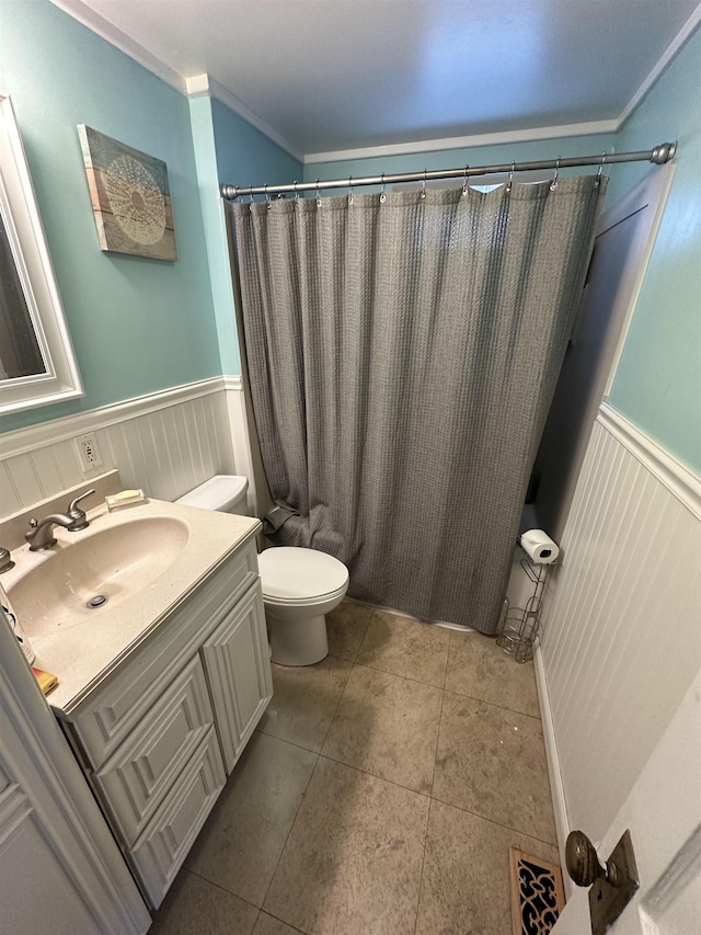 bathroom with tile patterned flooring, vanity, toilet, and crown molding