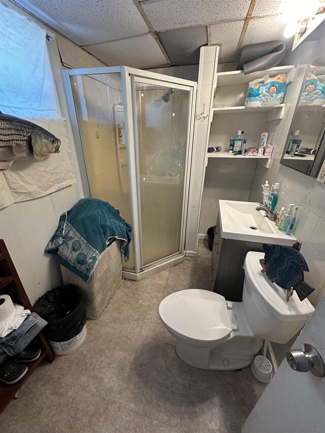 bathroom with vanity, a paneled ceiling, toilet, and walk in shower